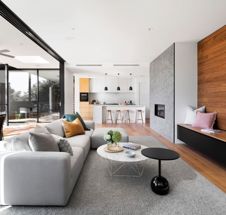 Bright open-concept living room and kitchen with modern finishes, large windows, and hardwood floors.