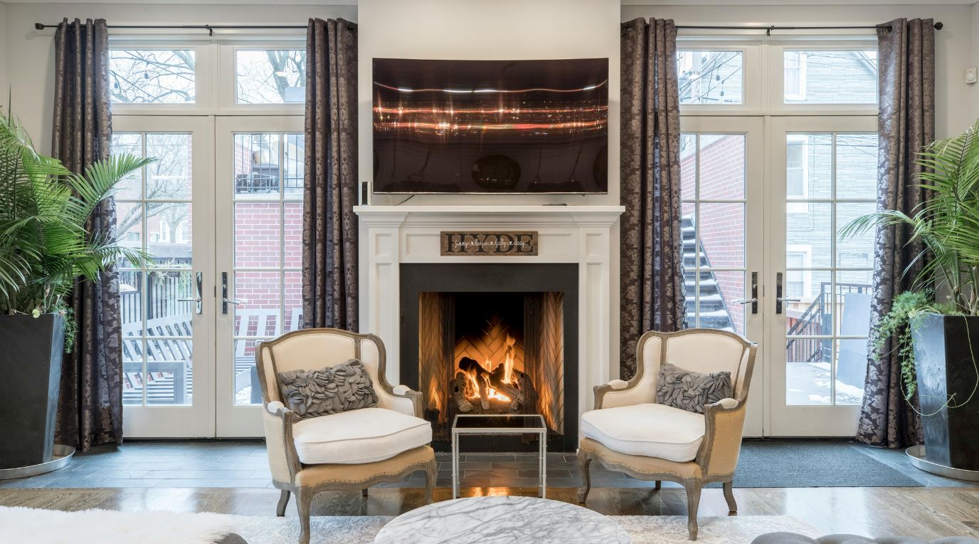 A professionally staged living room with a fireplace and French doors, prepared for sale.